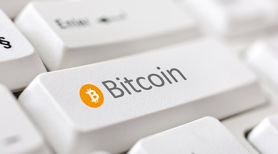 Moedas digitais: a palavra bitcoin escrita em uma tecla de teclado de computador.